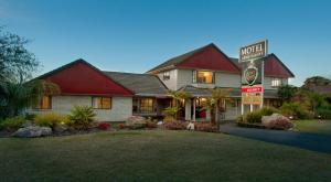 a motel sign in front of a house at Sport Of Kings Motel in Rotorua