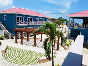 a blue building with a picnic table and a palm tree at Brisa Oceano Resort in Placencia
