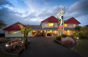 a house with a sign in front of it at Sport Of Kings Motel in Rotorua