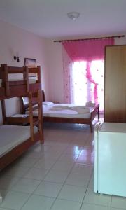 een kamer met 3 stapelbedden en een raam bij Oasis Drymades Hotel in Dhërmi