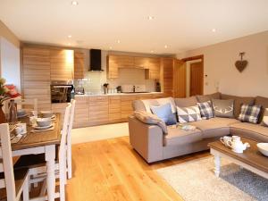a living room with a couch and a table and a kitchen at The Bay in Trearddur