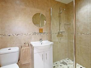 a bathroom with a shower and a toilet and a sink at The Bay in Trearddur +12 photos