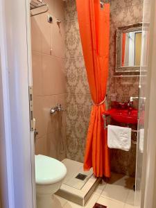 an orange shower curtain in a bathroom with a toilet at Hotel Mirto in Litochoro