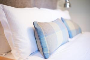 una fila de almohadas sentadas encima de una cama en Cromwell Arms Country Pub with Rooms, en Romsey