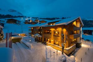 ein Gebäude im Schnee bei Nacht mit Lichtern in der Unterkunft Chalet Anna Maria in Lech am Arlberg