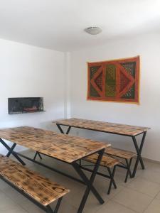 two picnic tables and two benches in a room at Hostel Ares do Mundo in Miguel Pereira