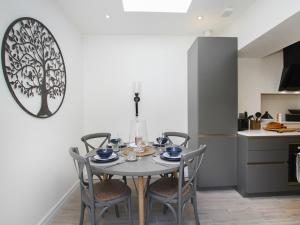 a dining room with a table and chairs in a kitchen at Tri Raglan Bach in Beaumaris