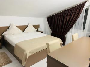 um quarto de hotel com uma cama e uma janela em FAST Airport Accomodation em Otopeni