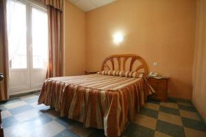 Tempat tidur dalam kamar di Hostal La Perla Asturiana