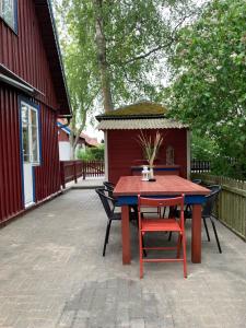 a table and chairs on a patio next to a red building at Skruzdynes 11 in Nida