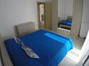 a bedroom with a blue bed and a mirror at Aquilone in Badesi