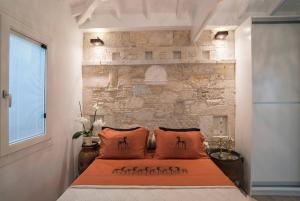 a bed in a room with a brick wall at Eftopia Beachfront Studio in Kokkari