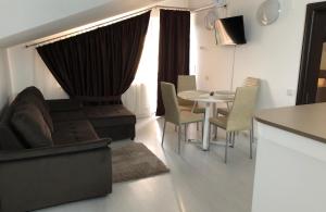 a living room with a couch and a table and chairs at FAST Airport Accomodation in Otopeni