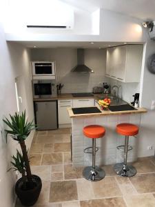 a kitchen with two orange bar stools and a counter at Cosy Studio Cours Lafayette "Clim, WIFI Gratuit" in Toulon