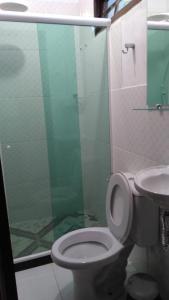 a bathroom with a toilet and a glass shower at Chales do Antonio in São Pedro da Serra +38 photos