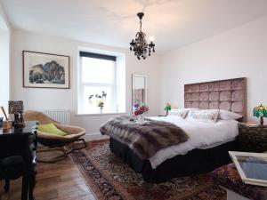 a bedroom with a large bed and a chandelier at Vista Marina - Penthouse in Criccieth