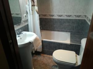 a bathroom with a toilet and a sink and a tub at Vivienda Rural Alcazaba in Chipiona