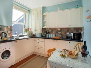 a kitchen with a table with a plate of food on it at 17 Victoria Terrace - Perthi in Nantlle