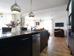 a kitchen with black cabinets and a living room at Vista Marina - Penthouse in Criccieth +7 photos