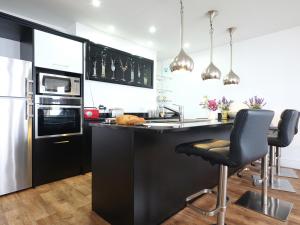 a kitchen with a black counter and a refrigerator at Vista Marina - Penthouse in Criccieth