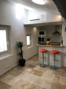 a kitchen with two orange stools in a kitchen at Cosy Studio Cours Lafayette "Clim, WIFI Gratuit" in Toulon