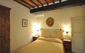 a bedroom with a bed with two night stands and lights at Appartamento Il Loggiato in Cortona