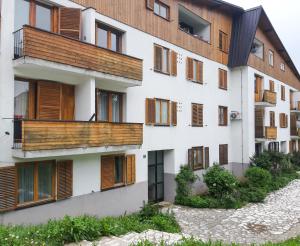 un edificio de apartamentos con balcones de madera y un patio en Sweet Dreams en Lagos de Plitvice