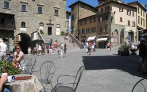 a group of people walking around a street with buildings at Appartamento Il Loggiato in Cortona