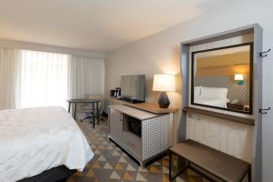 a hotel room with a bed and a mirror at Holiday Inn & Suites Orlando SW - Celebration Area, an IHG Hotel in Orlando