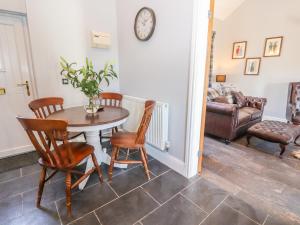 a dining room with a table and chairs and a couch at Clwyd Cottage in St Asaph