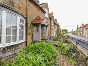 a row of brick houses with flowers in front of them at 11A High Street in Scarborough