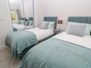 1 dormitorio con 2 camas y espejo en Tinners Rest, en Penzance