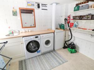 - un lave-linge dans la cuisine équipée d'un évier dans l'établissement The Groom's House, à Callington