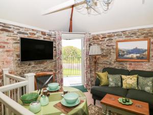 a living room with a couch and a tv at The Bothy in Callington