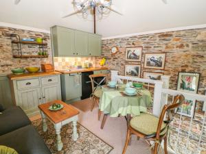 a living room with a table and a kitchen at The Bothy in Callington