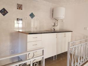 a kitchen with white cabinets and a counter top at Casa Bento Teixeira in Belmonte