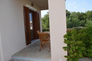 a porch of a house with a table and chairs at Guest Rooms Affittacamere in San Teodoro