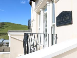 a balcony of a white building with a sign on it at 10 Cove View in Ilfracombe