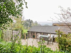 a wooden deck in front of a house at Wellinghill Lodge in Cheltenham