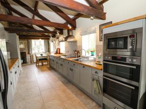 a kitchen with stainless steel appliances and wooden beams at The Groom's House in Callington