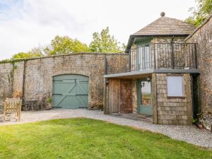 an old brick building with a green garage at The Bothy in Callington