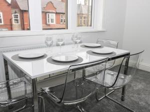 a white table with four chairs and wine glasses at Angel by the Sea in Bridlington