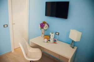a white desk with a lamp and flowers on it at Affittacamere Rosy in La Spezia