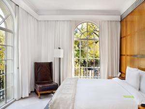 a bedroom with a bed and a chair and a window at Condesa df, Mexico City, a Member of Design Hotels in Mexico City
