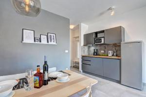 a kitchen with a wooden table and a kitchen with a refrigerator at Apartman D in Pula