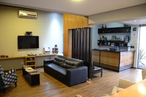 a living room with a couch and a bar at Ideali Hotel in Ribeirão Preto