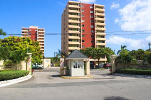 a small building in the middle of a street with tall buildings at Surf Turf Two Bedroom Suite At Turtle Towers in Ocho Rios