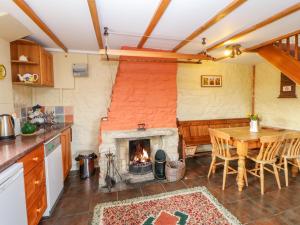a kitchen with a fireplace and a table and a dining room at Beckelshele in Bishop Auckland