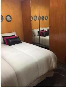 a large white bed in a room with a mirror at Aurora... Pisos en alquiler Granada. Armilla in Armilla