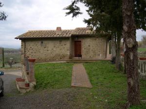 Kamienny dom z ceglaną ścieżką przed nim w obiekcie Agriturismo Bonacchi w mieście Montalcino
